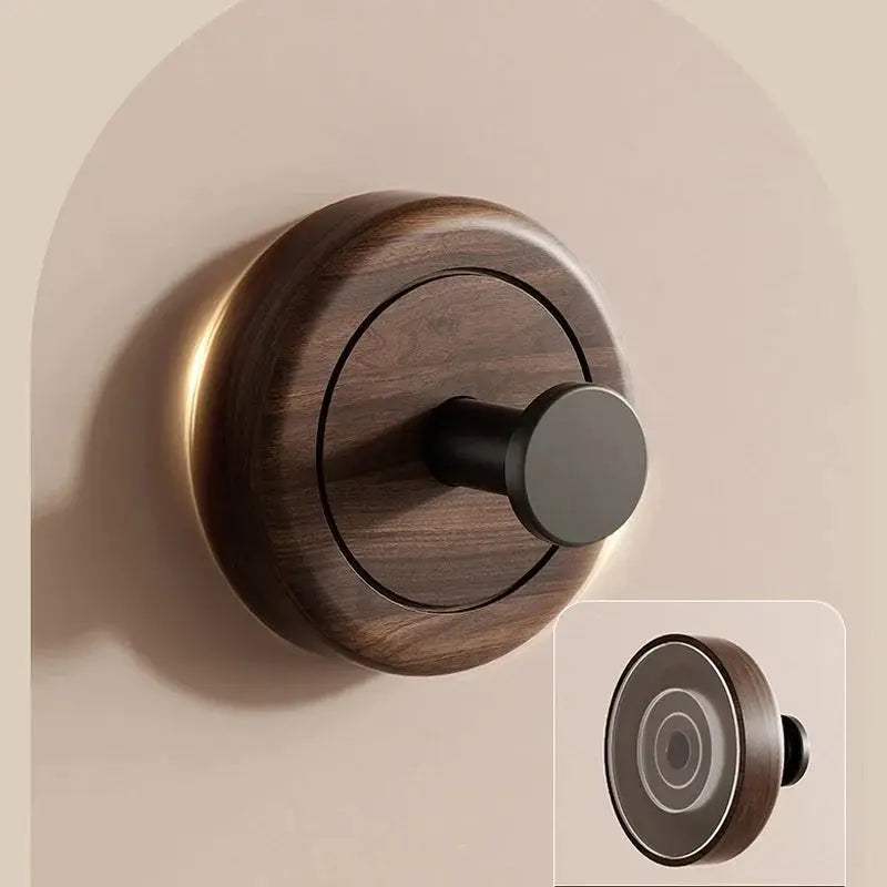 The Hang Walnut Wood Suction Cup Hook on a wall, showcasing a modern walnut design and no-drill installation.